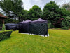 Lay-z-days Event's UV trippy rave party tent, 6x4.5 meters, with vibrant lighting, set up for outdoor event or party.