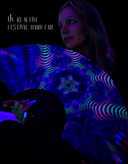 Person holding a glowing UV reactive festival hand fan with text overlay on a dark background
